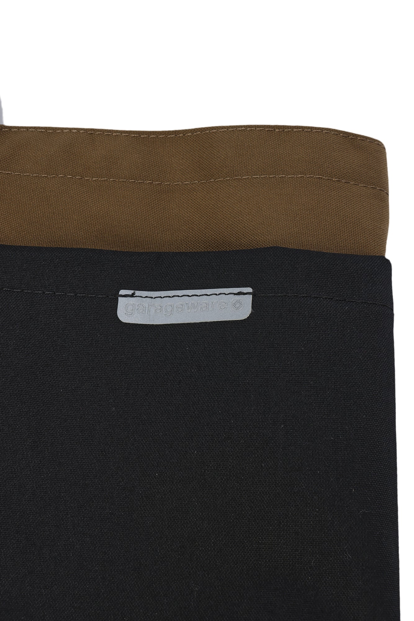 Close-up of a black garment with a brown collar on a white background