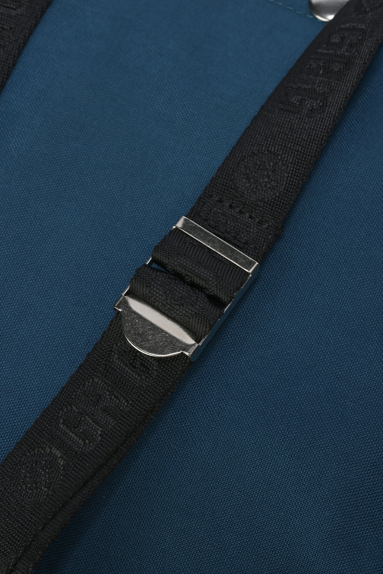 Black strap with silver buckle on a blue background